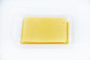 sottilmente affettato fette di formaggio su un' plastica sostegno. delizioso tritato giallo formaggio. formaggio nel un' pacchetto a partire dal il negozio. foto