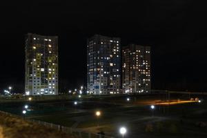 panorama notturno di luce nelle finestre di un edificio a più piani. vita in una grande città foto