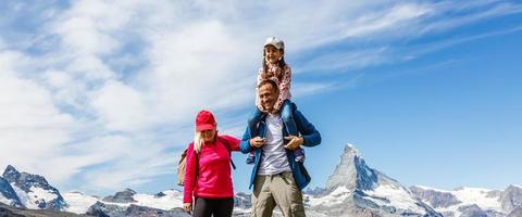 contento famiglia con poco bambino fare il trekking su Svizzera montagna nel estate volta. giovane persone avendo divertimento nel paesaggio natura. concetto di viaggiare, amichevole famiglia foto