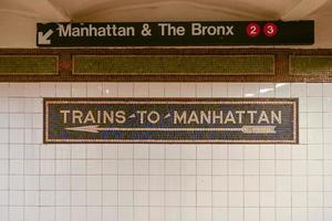 treni per Manhattan mosaico freccia cartello nel il nyc metropolitana. foto