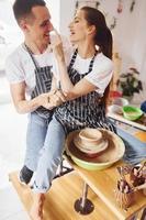 con sua fidanzato o marito. giovane femmina ceramista in casa con fatto a mano argilla Prodotto. concezione di ceramica foto