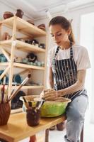 giovane femmina ceramista Lavorando di utilizzando ceramica ruota in casa e fabbricazione fatto a mano argilla Prodotto foto