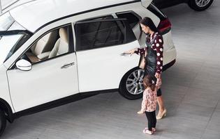 madre con sua figlia a piedi insieme vicino moderno automobile in casa foto