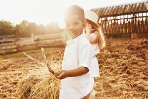 carino poco africano americano ragazzo con europeo ragazza è su il azienda agricola foto