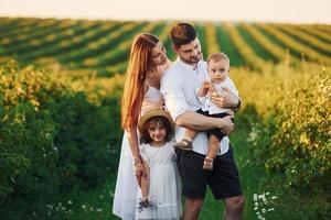 padre, madre con figlia e figlio la spesa gratuito tempo all'aperto a soleggiato giorno tempo di estate foto