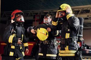 indossare protettivo uniforme. gruppo di i vigili del fuoco quello è su stazione foto