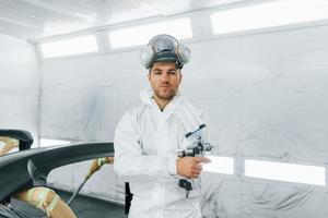 pronto per il la pittura. uomo nel uniforme è Lavorando nel il auto servizio foto