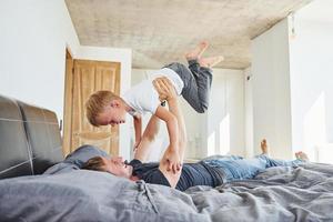 posa giù su il letto. padre e figlio è in casa a casa insieme foto