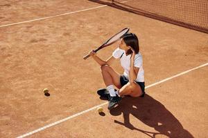 vicino il rete. femmina tennis giocatore è su il Tribunale a giorno foto