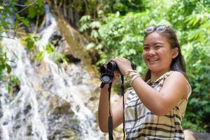 ragazza utilizzando binocolo nel foresta foto