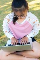 ragazza Lavorando con il computer portatile su erba foto