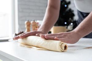 maschio capocuoco Lavorando con Impasto, cucinando cannella rotoli foto