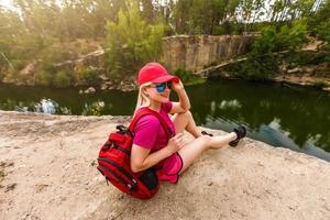 un' giovane ragazza si siede su un' scogliera contro il sfondo di il canyon e il fiume. fiume nel il primavera. foto