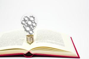 leggero lampadina con Ingranaggio o ruota dentata è posto su libro. concetto di conoscenza, saggezza, nuovo idee e creatività. foto