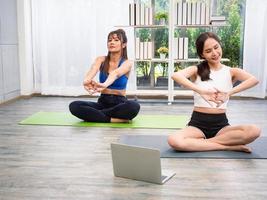 bellissimo giovane asiatico donne lgbt lesbica coppia contento coppia Guardando il yoga video lezione su un' il computer portatile nel il vivente camera, lgbt lesbica salutare stile di vita il coppia insieme in casa concetto. foto