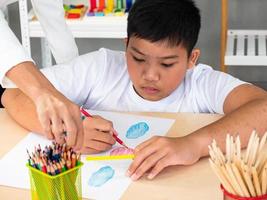 un'allegra lezione di arti creative di gruppo per bambini e il loro insegnante nell'aula scolastica, scolari felici che giocano a un interessante gioco da tavolo durante una lezione in classe foto