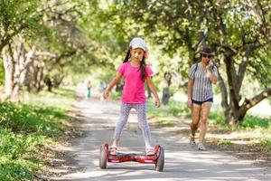 un' poco ragazza equitazione un' elettrico scooter . personale eco trasporto , giroscopio scooter, intelligente equilibrio ruota.popolare elettrico trasporto foto