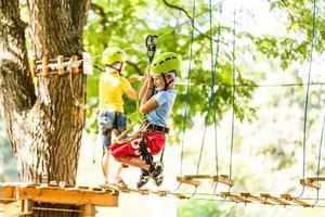 avventura arrampicata alto filo parco - bambini su corso corda parco nel montagna casco e sicurezza attrezzatura foto