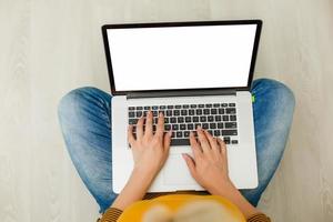 superiore Visualizza di un' giovane donna Tenere il computer portatile computer su sua giro mentre seduta a casa foto