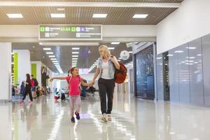 indietro Visualizza di madre e bambino andando insieme su sfondo. shopping centro commerciale, aeroporto viaggiare, amore cura, protezione concetto. foto