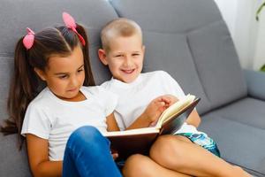 bambini leggere un' libro a casa foto