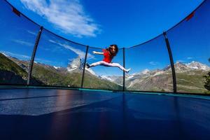 poco ragazza su un' trampolino nel il montagne, Alpi foto