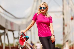 indietro Visualizza di giovane sottile donna in piedi a bicicletta su ponte sfondo. attivo stile di vita e vacanze concetto. foto