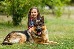 bella poco ragazza, dà un' comando per sedersi per Tedesco pastore cane. foto