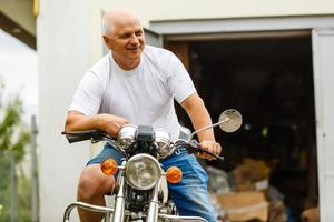 un anziano uomo seduta su un' motociclo. foto