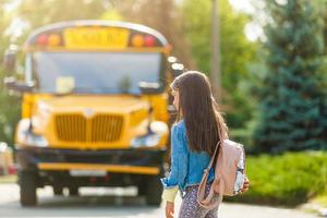 scolara è in attesa per un' scuola autobus foto