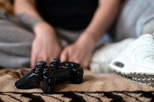 moderno nero gioco controllore nel il mani di un' seduto giovane ragazza foto