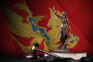 montenegro bandiera con statua di signora giustizia, costituzione e giudice martello su nero drappeggio. concetto di giudizio e colpa foto