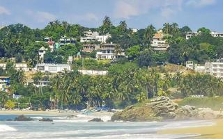 sole spiaggia persone onde e Barche nel puerto escondido Messico. foto