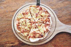Pizza formaggio fetta su di legno vassoio e servito su un' di legno tavolo , superiore Visualizza fatti in casa Pasticcino Pizza italiano è cucinato tradizionale cibo foto