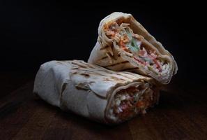 shawarma con succoso gustoso Riempimento bugie su un' di legno tavola. affettato shawarma. foto