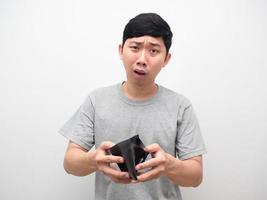 asiatico uomo sentire scioccato di no i soldi Tenere vuoto portafoglio nel mano foto