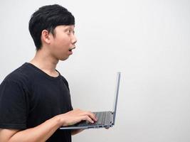giovane uomo Tenere il computer portatile sentire stupito guardare inoltrare lato Visualizza foto