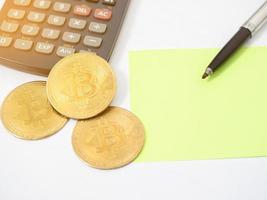 vicino su oro bitcoin con penna e carta superiore vista, posto di lavoro isolato leggero bagliore foto