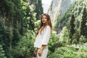 giovane donna viaggiatore con lungo bionda capelli sembra a il bellissimo Visualizza di montagne foto