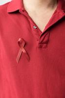 nastro rosso bordeaux per il cancro del mieloma multiplo di marzo e il mese di sensibilizzazione della giornata mondiale contro l'aids. concetto di salute e giornata mondiale del cancro foto