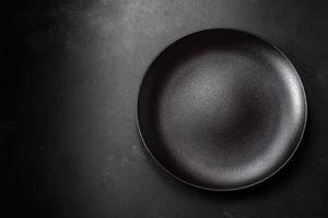 vuoto bellissimo nero ceramica piatto su un' buio calcestruzzo sfondo foto