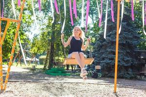 bellissimo giovane biondo donna su un' swing sfondo foto