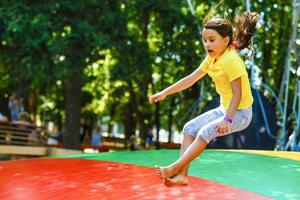 contento poco ragazza avendo divertimento mentre salto su trampolino foto