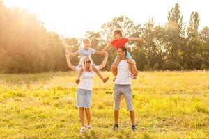 giovane famiglia in esecuzione attraverso un' giallo campo foto