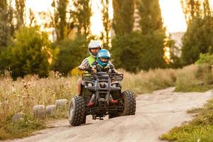 poco ragazzo con istruttore su un' quadrilatero bicicletta foto