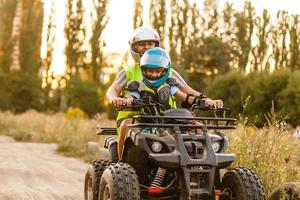 poco ragazzo con istruttore su un' quadrilatero bicicletta foto