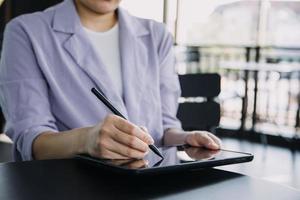 asiatico colleghi uomo e donna discutere e Lavorando con il computer portatile computer su ufficio scrivania nel il ufficio foto