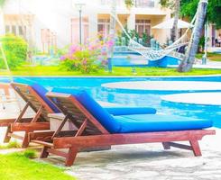 sole letti e sdraio con spiaggia ombrelli vicino piscina nel il tropicale ricorrere Hotel. foto