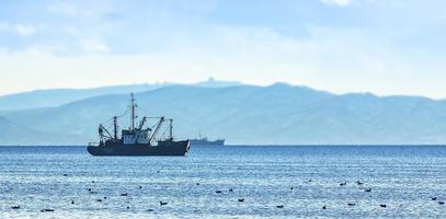 barca da pesca in grigio mattino sull'Oceano Pacifico al largo della penisola di Kamchatka foto