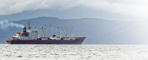selettivo messa a fuoco. pesca barca nel grigio mattina su Pacifico oceano via il costa di il kamchatka penisola foto